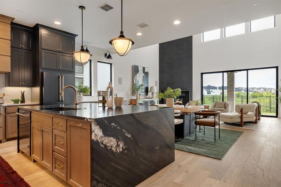 Kitchen with plenty of natural light, open floor plan, a kitchen island with sink, recessed lighting, and a towering ceiling Kitchen with plenty of natural light, open floor plan, a kitchen island with sink, recessed lighting, and a towering ceiling
