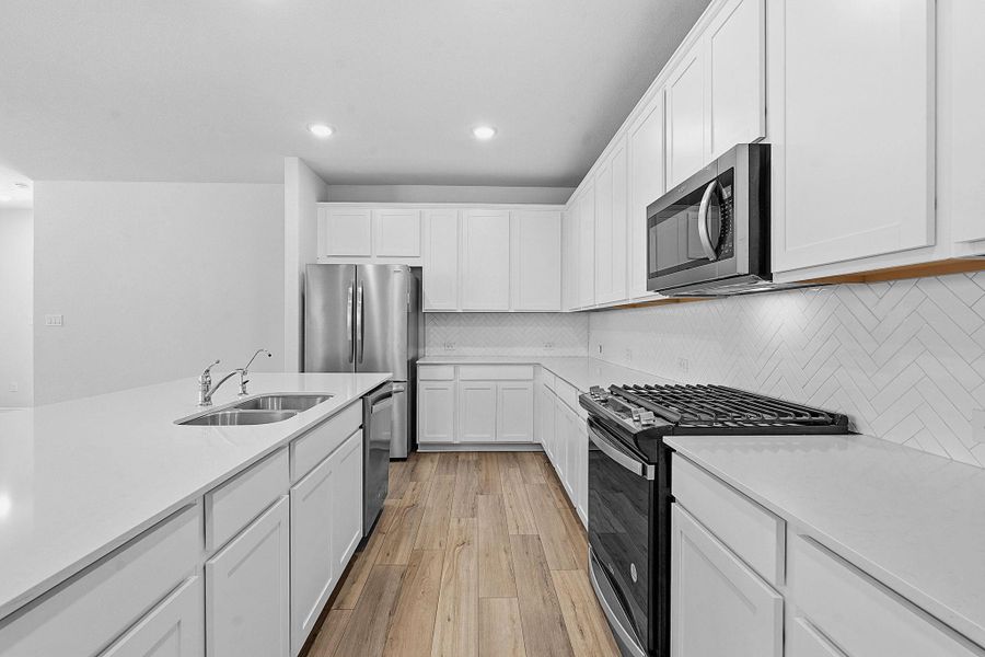 A well-appointed kitchen showcasing bright cabinetry, stainless steel appliances, and sleek countertops. A well-appointed kitchen showcasing bright cabinetry, stainless steel appliances, and sleek countertops.