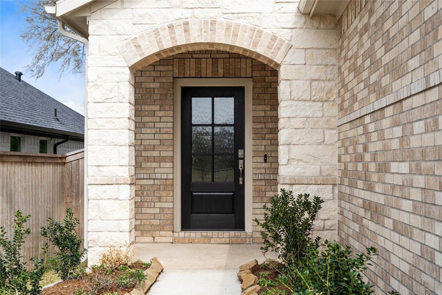 Exceptional curb appeal defines this residence, featuring a beautiful limestone and brick exterior. A stately arched entrance and designer six-lite black door create a bold, sophisticated welcome for every guest.