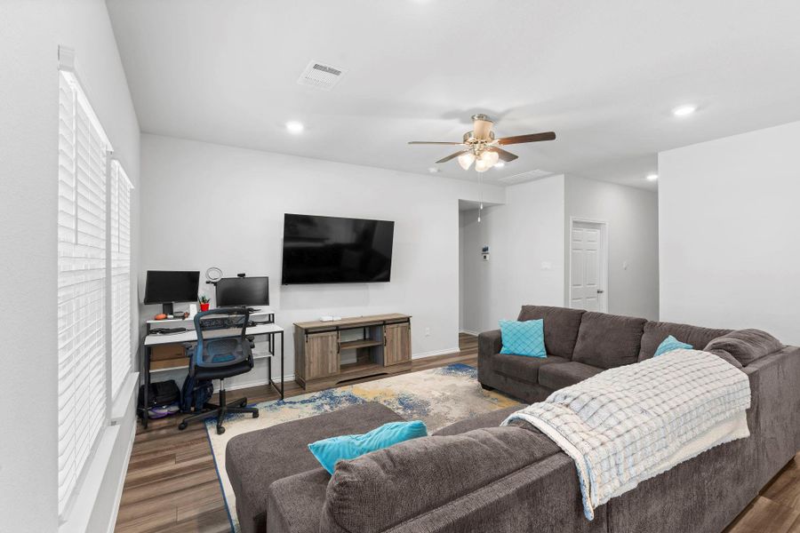 Hardwood-style flooring and overhead lighting complement a spacious living area. Hardwood-style flooring and overhead lighting complement a spacious living area.