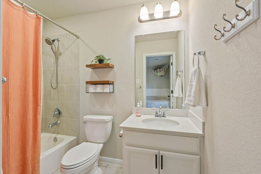 Bathroom features a clean and modern design with a tiled shower and tub, complemented by a sleek white vanity with a large mirror, overhead lighting, and practical shelving for storage. The neutral color palette creates a fresh and inviting atmosphere. Bathroom features a clean and modern design with a tiled shower and tub, complemented by a sleek white vanity with a large mirror, overhead lighting, and practical shelving for storage. The neutral color palette creates a fresh and inviting atmosphere.