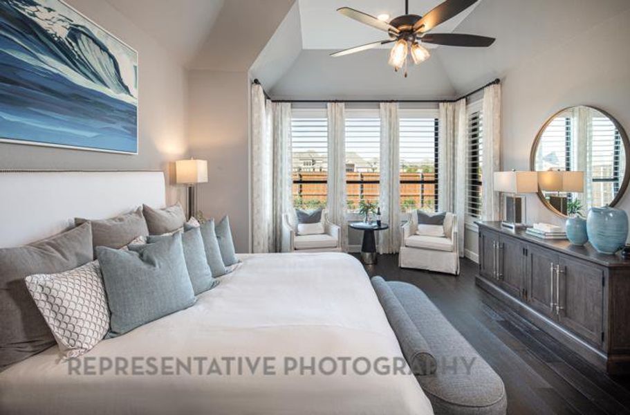Bedroom featuring multiple windows, dark wood-style floors, vaulted ceiling, and ceiling fan Bedroom featuring multiple windows, dark wood-style floors, vaulted ceiling, and ceiling fan