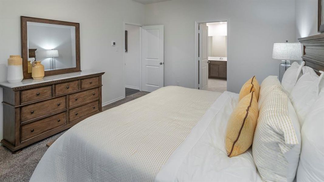 Carpeted bedroom featuring ensuite bathroom
