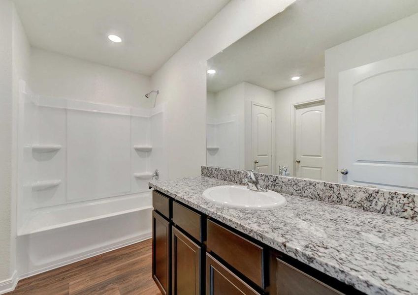 Frio bathroom with granite counters, white fixtures, and bath/tub combo unit