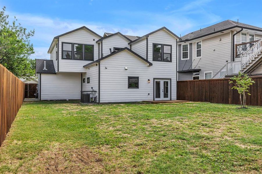 Rear view of property with french doors, a fenced backyard, and a shingled roof Rear view of property with french doors, a fenced backyard, and a shingled roof