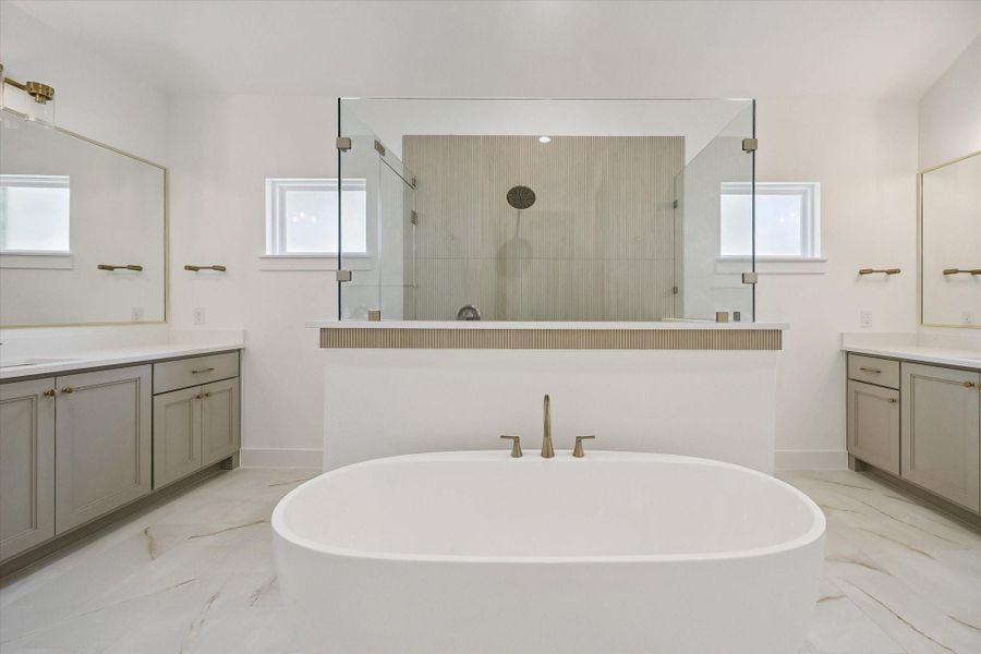Spa-like Primary Bath with 2 separate vanities, walk-in shower, and deep soaking bathtub.