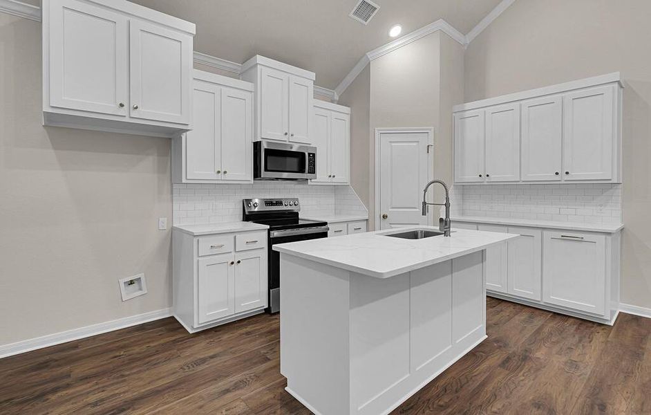Kitchen featuring appliances with stainless steel finishes, crown molding, decorative backsplash, white cabinets, and recessed lighting