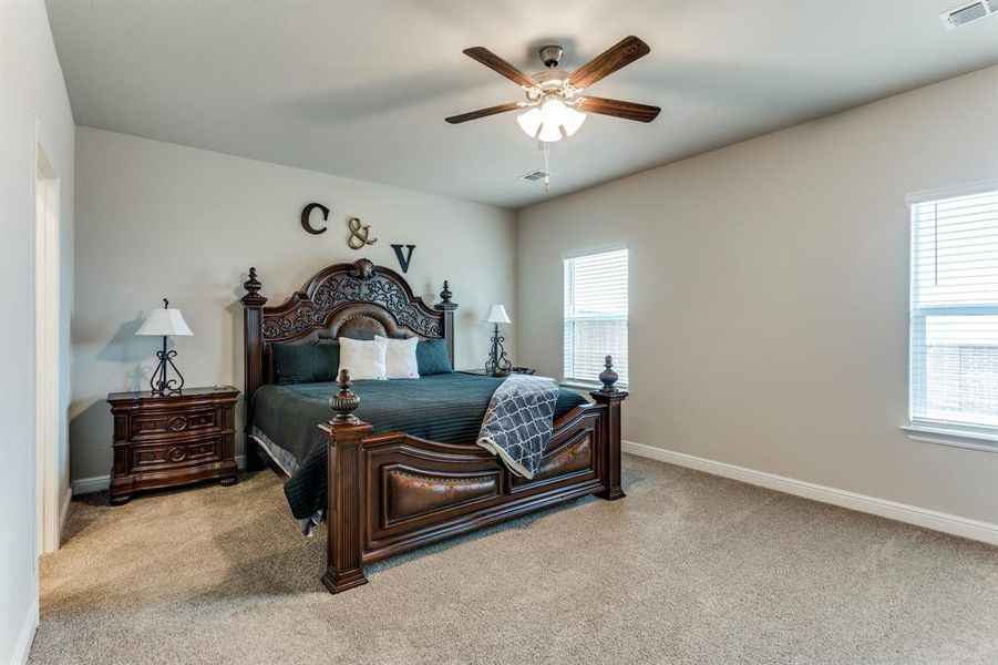 Carpeted bedroom featuring ceiling fan