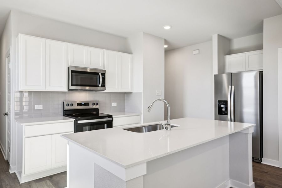 A kitchen with white cabinets.