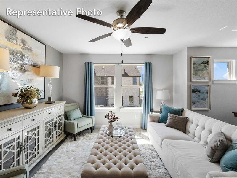 Carpeted living room featuring ceiling fan