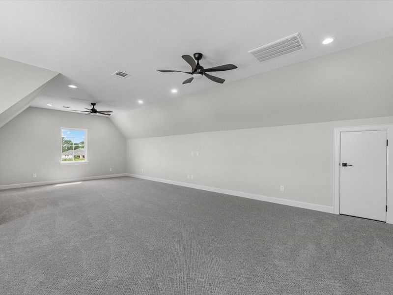 Spacious upstairs bonus room with multiple windows, ideal for a game room, media space, or flex living.