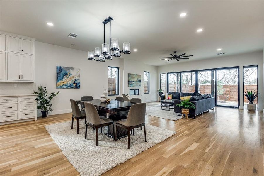 Dining space featuring light hardwood / wood-style flooring and ceiling fan with notable chandelier