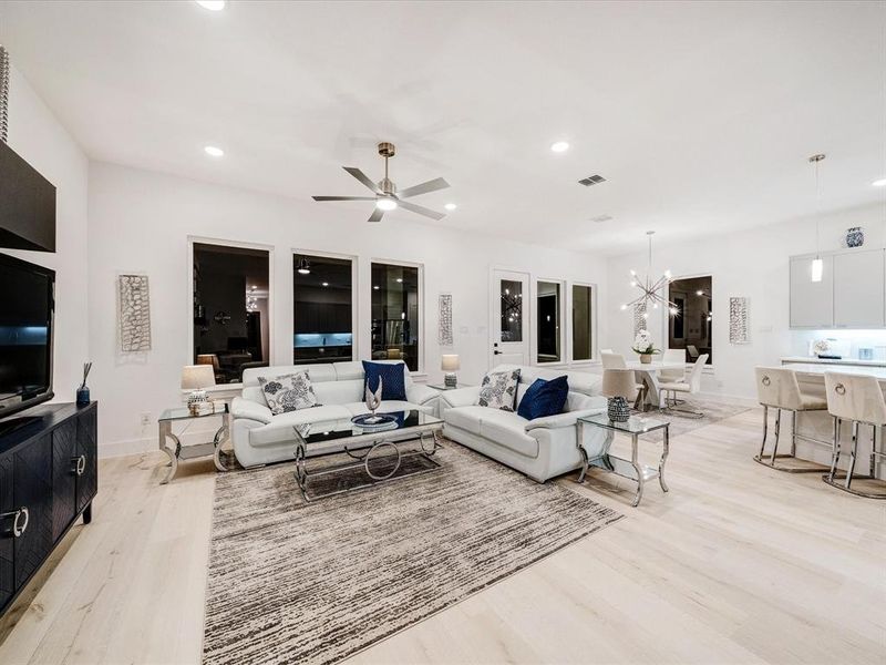 Living area featuring recessed lighting, ceiling fan, light wood finished floors, and a chandelier Living area featuring recessed lighting, ceiling fan, light wood finished floors, and a chandelier