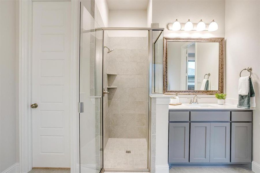 Bathroom featuring a shower with door and vanity