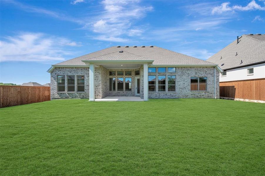 Expansive backyard featuring a large grass lawn, privacy fencing, and a covered concrete patio Expansive backyard featuring a large grass lawn, privacy fencing, and a covered concrete patio
