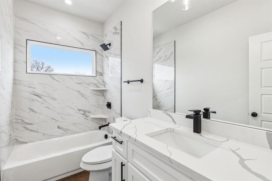 Full bathroom featuring toilet, tiled shower / bath, and vanity