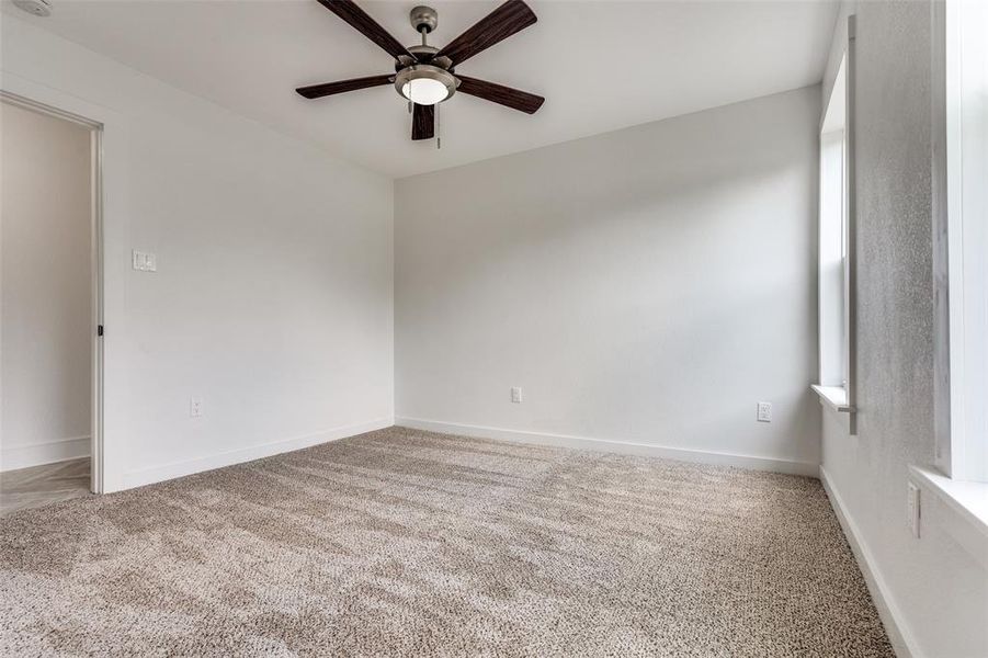 Carpeted empty room with ceiling fan