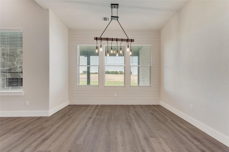 Unfurnished dining area with hardwood / wood-style floors and wood walls