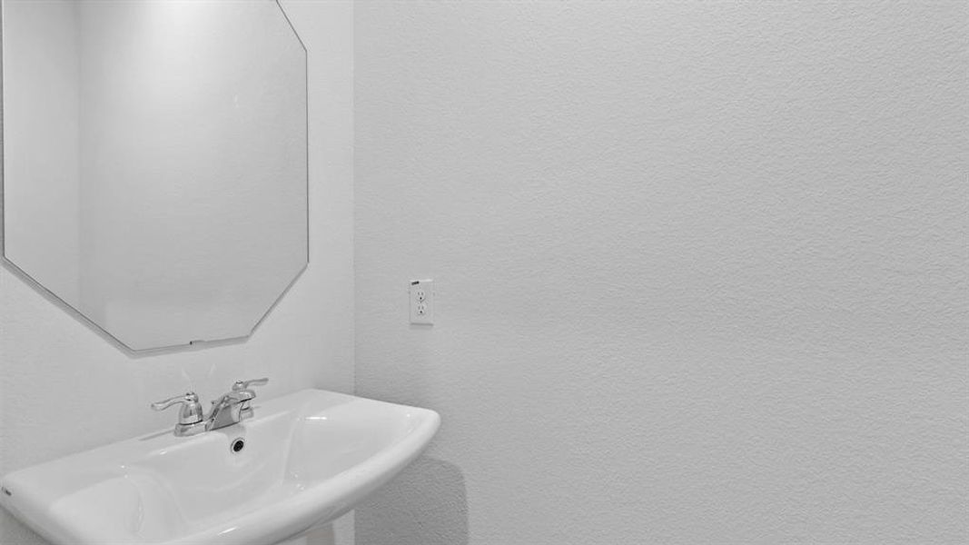 Pedestal sink with chrome fixtures and an octagonal mirror Pedestal sink with chrome fixtures and an octagonal mirror