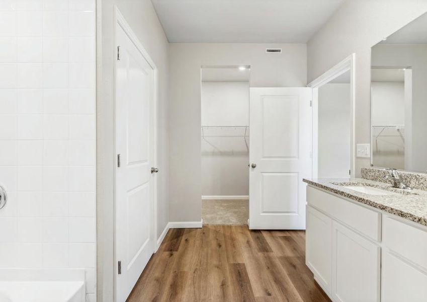 The master bathroom is spacious with a large vanity.