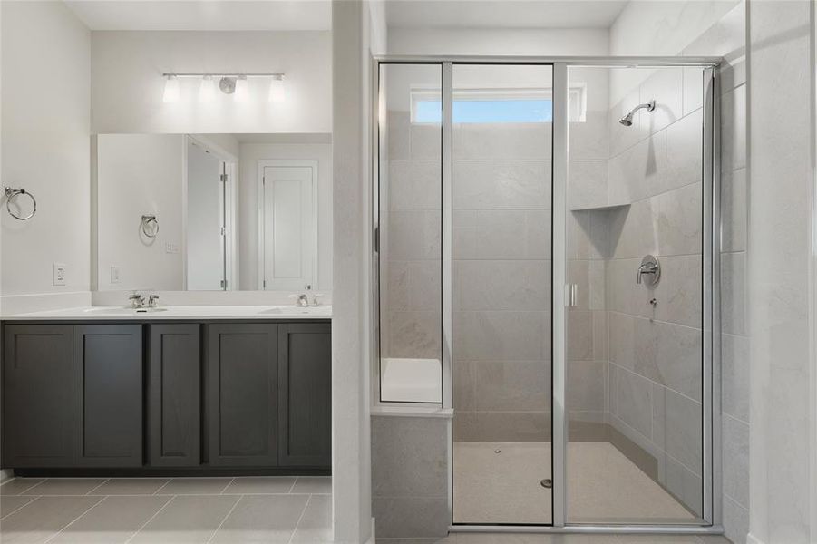 Bathroom with a shower stall, double vanity, and tile patterned flooring Bathroom with a shower stall, double vanity, and tile patterned flooring