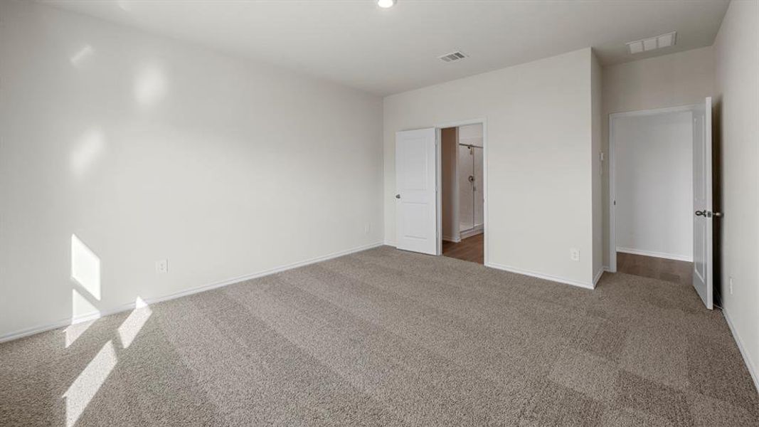 Unfurnished bedroom with dark carpet and baseboards
