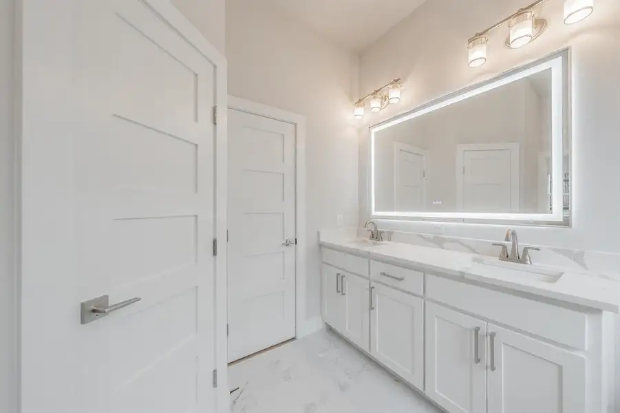Full bathroom with double vanity and light marble finish floors