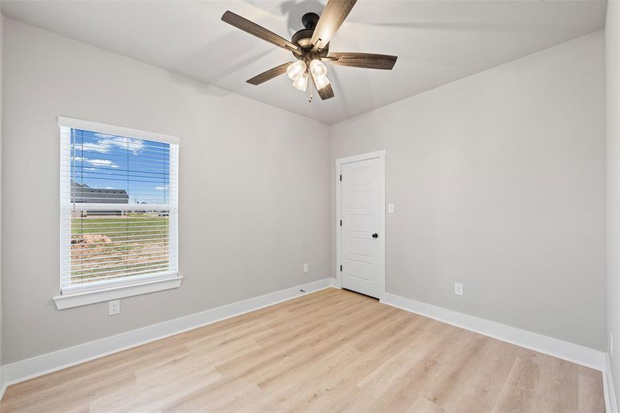 Empty room featuring light wood-type flooring and ceiling fanflooring and ceiling fan Empty room featuring light wood-type flooring and ceiling fanflooring and ceiling fan