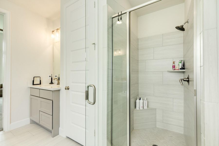 Primary bath featuring a luxurious, oversized glass walk-in shower equipped with a convenient built-in ledge for your personal items. Primary bath featuring a luxurious, oversized glass walk-in shower equipped with a convenient built-in ledge for your personal items.