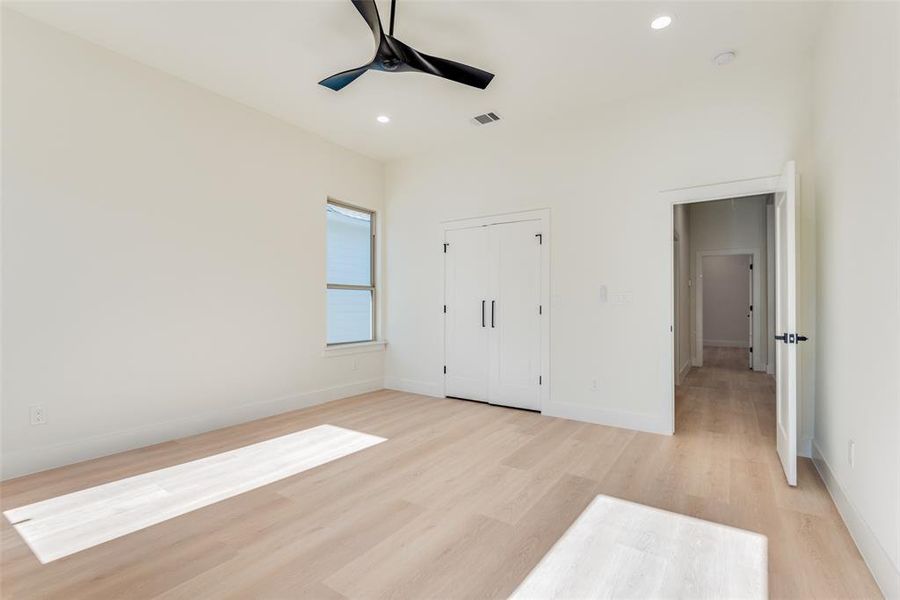 Unfurnished bedroom featuring light wood-style flooring, a ceiling fan, recessed lighting, and a closet