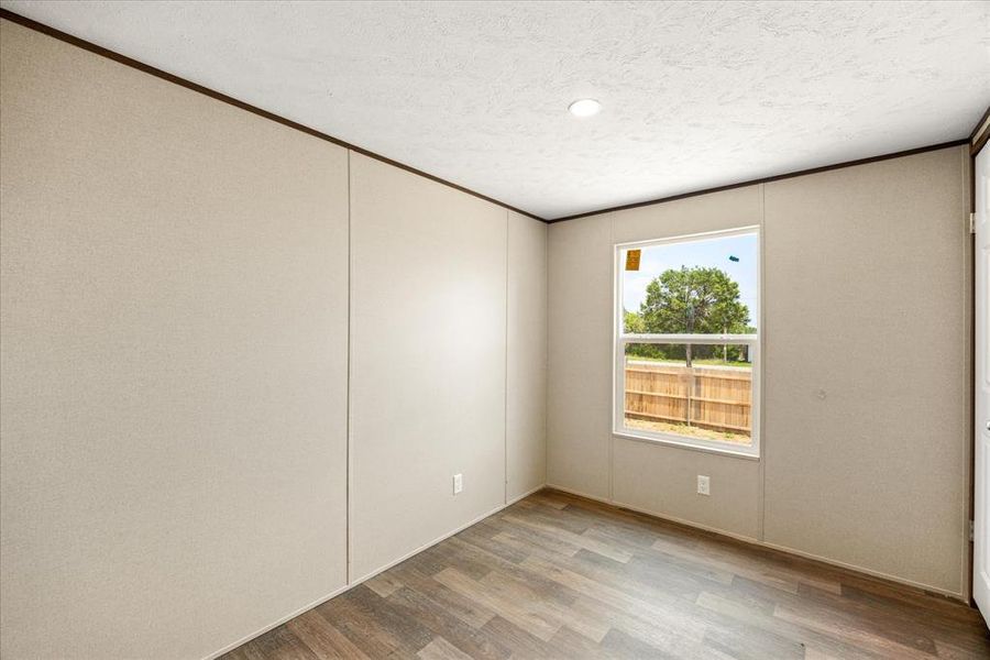 Room featuring wood-finish flooring, a single-pane window, and a recessed ceiling light fixture