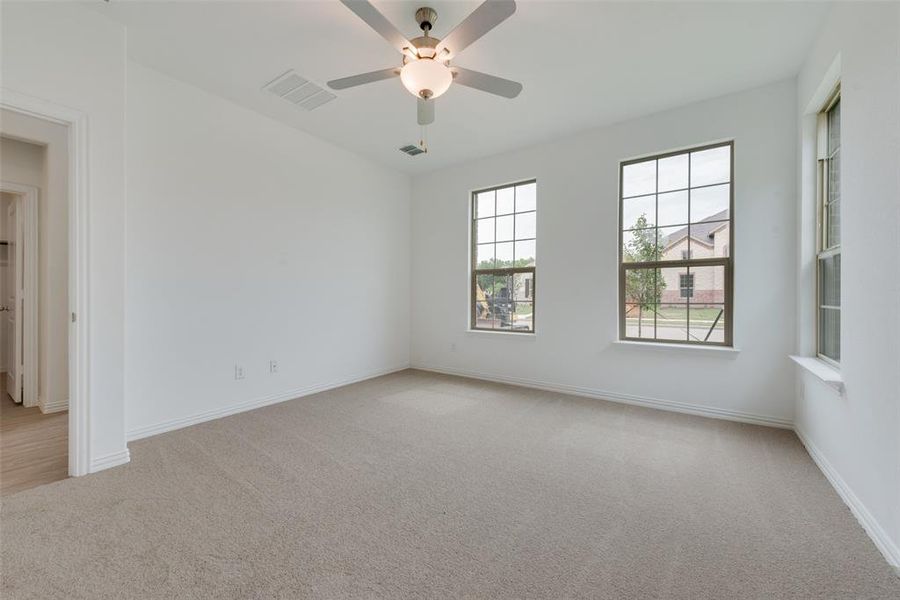 Spare room with ceiling fan and light colored carpet