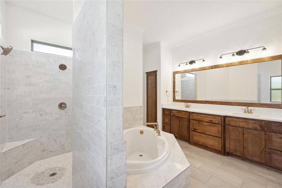 Bathroom with plenty of natural light, tile patterned flooring, dual bowl vanity, and separate shower and tub