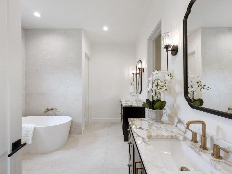 A well-appointed bathroom with a freestanding tub and a vanity featuring a lustrous marble countertop.