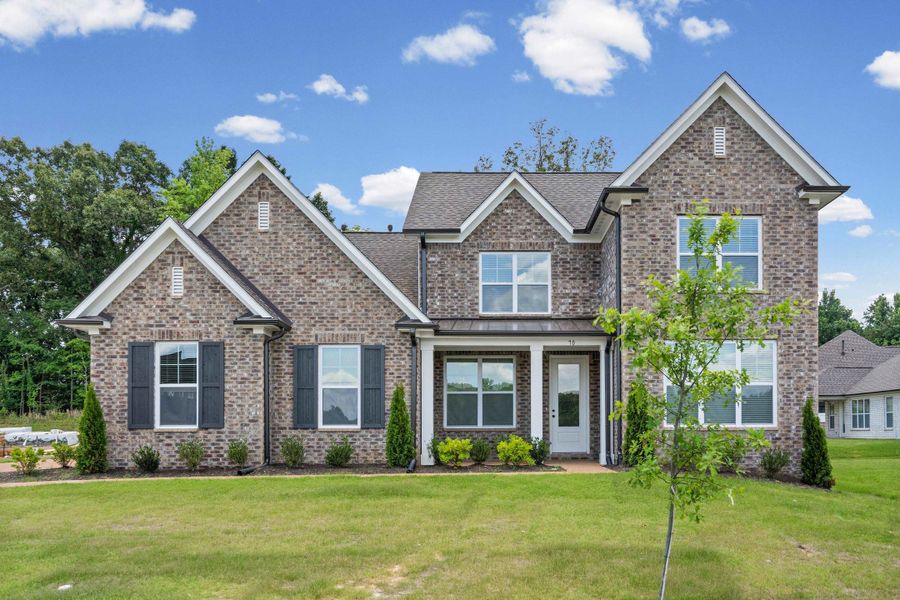 Multi-level brick exterior featuring gabled roofs, dark shutters, white trim, and a covered entryway Multi-level brick exterior featuring gabled roofs, dark shutters, white trim, and a covered entryway