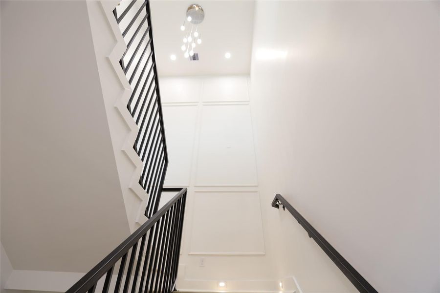 35-foot floor-to-ceiling accent wall makes a dramatic statement, paired with a radiant 9FT chandelier that fills the space with light as you ascend. The staircase showcases exquisite craftsmanship, with step-by-step carpentry details that add timeless charm and elegance. 35-foot floor-to-ceiling accent wall makes a dramatic statement, paired with a radiant 9FT chandelier that fills the space with light as you ascend. The staircase showcases exquisite craftsmanship, with step-by-step carpentry details that add timeless charm and elegance.