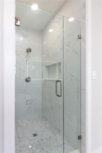Full bath with a marble finish shower