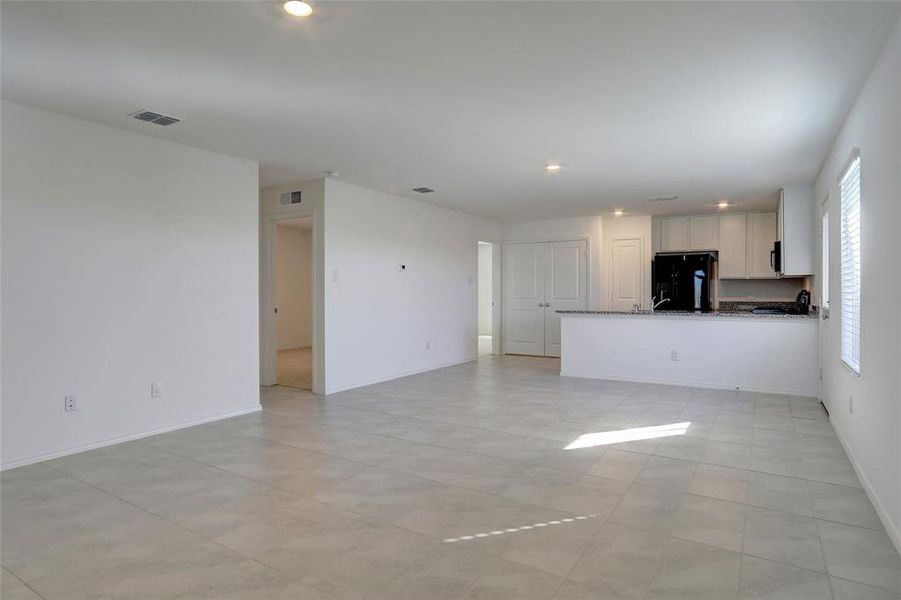 Unfurnished living room featuring recessed lighting and light tile patterned floors