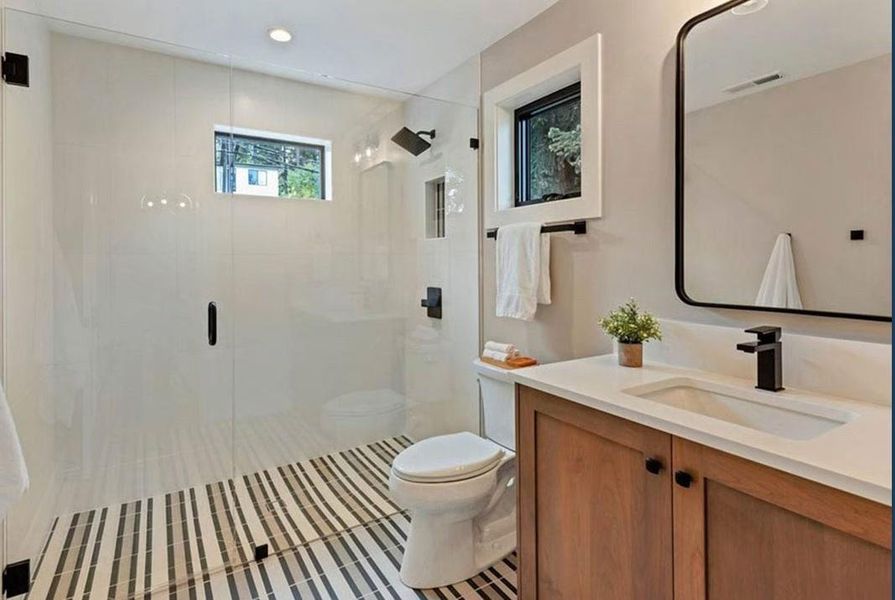 Full bathroom featuring vanity, a shower stall, and light tile patterned floors