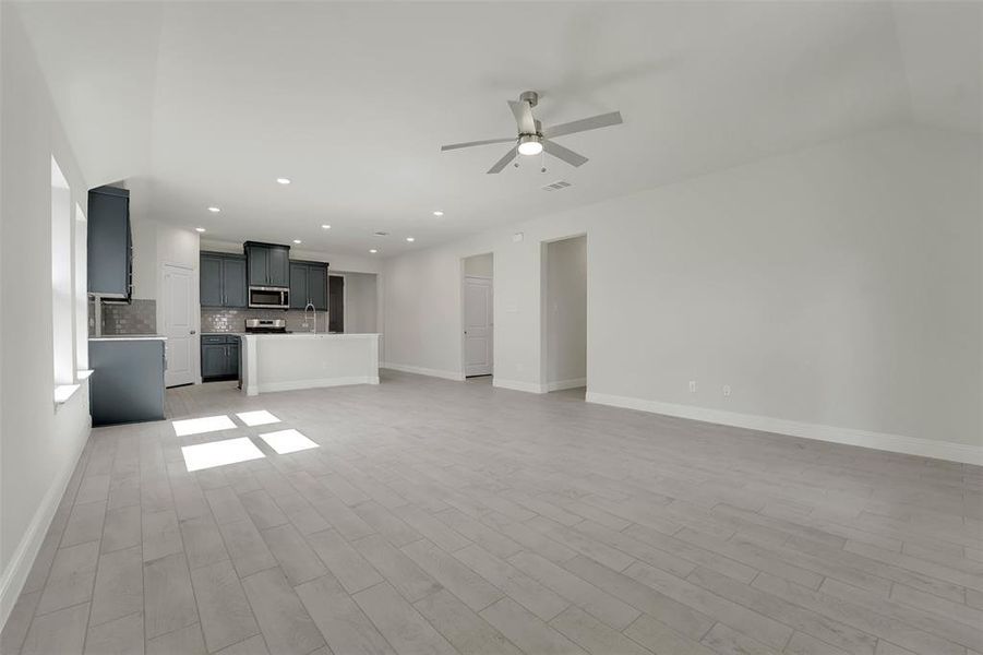 Unfurnished living room featuring baseboards, visible vents, a ceiling fan, light wood-style flooring, and recessed lighting Unfurnished living room featuring baseboards, visible vents, a ceiling fan, light wood-style flooring, and recessed lighting