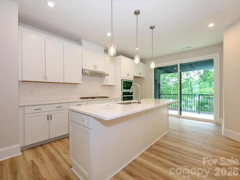 Gourmet kitchen with white cabinets and white quartz countertops