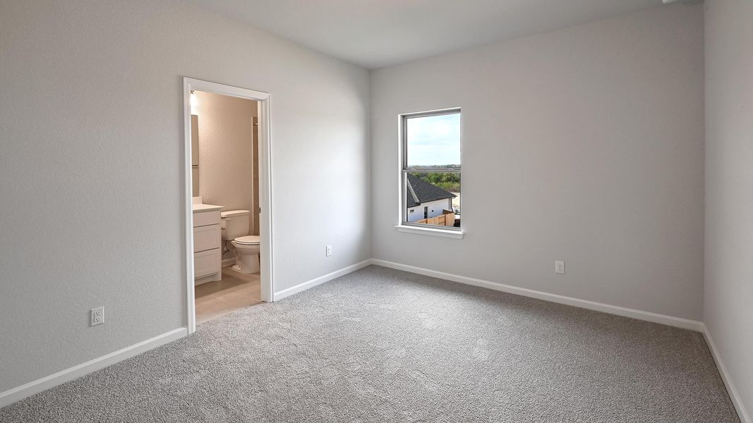 Unfurnished bedroom featuring light carpet and ensuite bath Unfurnished bedroom featuring light carpet and ensuite bath
