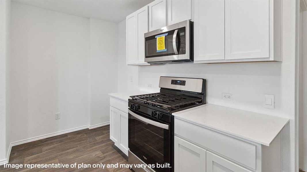 Kitchen featuring stainless steel appliances, white cabinets, dark wood finished floors, and light stone countertops