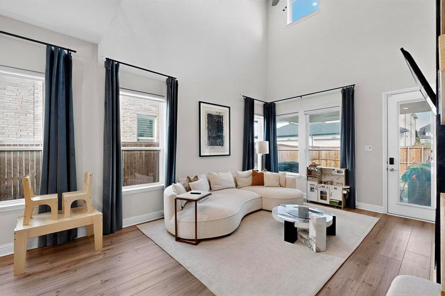 Living room with light wood finished floors and a high ceiling Living room with light wood finished floors and a high ceiling