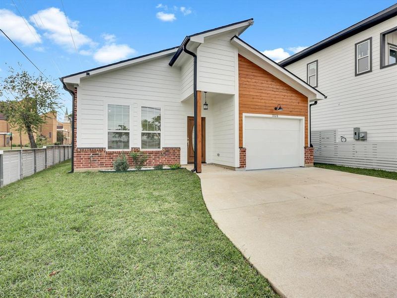 View of front of property with a front lawn and a garage