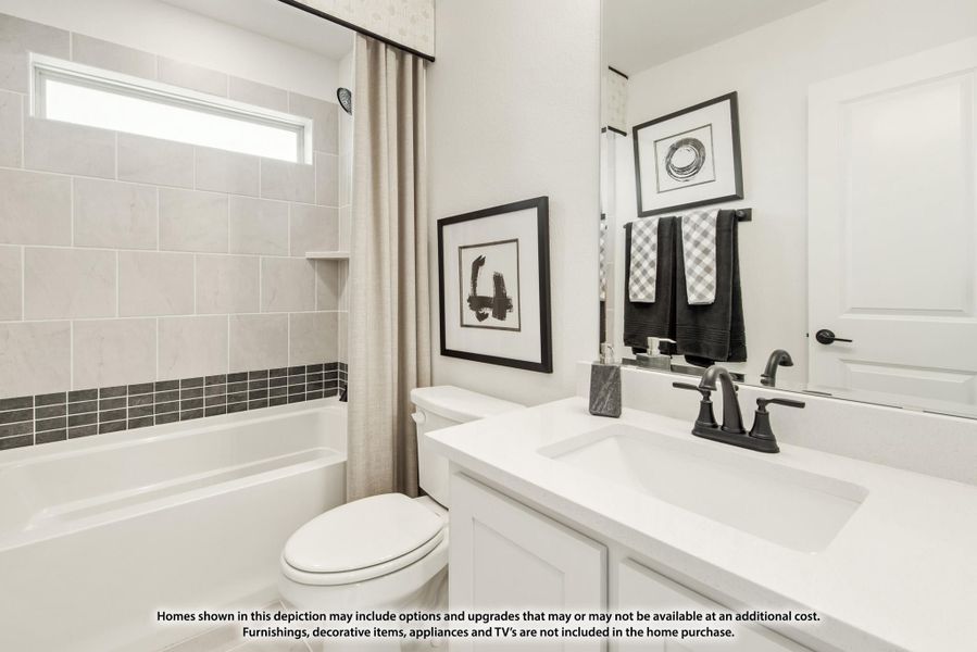 Bathroom with white vanity, dark faucet, tiled tub surround, and shower curtain Bathroom with white vanity, dark faucet, tiled tub surround, and shower curtain