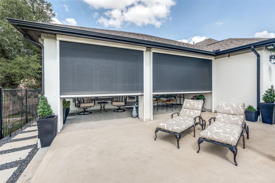 Retractable screens enclose a concrete patio area, blending indoor and outdoor living space.
