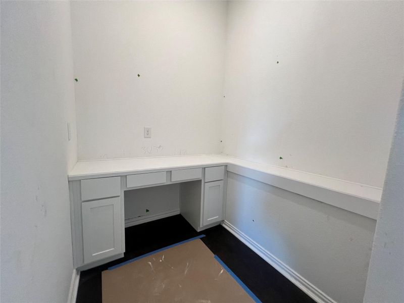 Unfurnished office with built in desk and baseboards