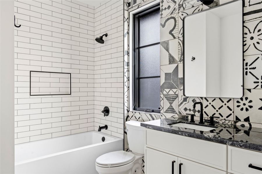 Bathroom with vanity, shower / tub combination, and decorative backsplash