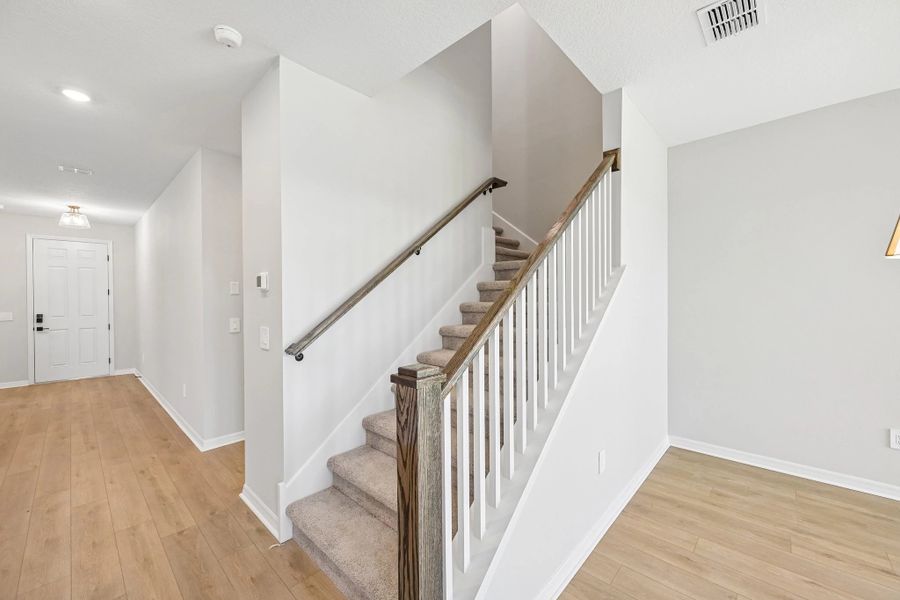 The staircase features an open rail and wooden spindles